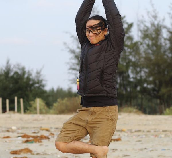 Smiling person in a meditative yoga posture at sunrise.