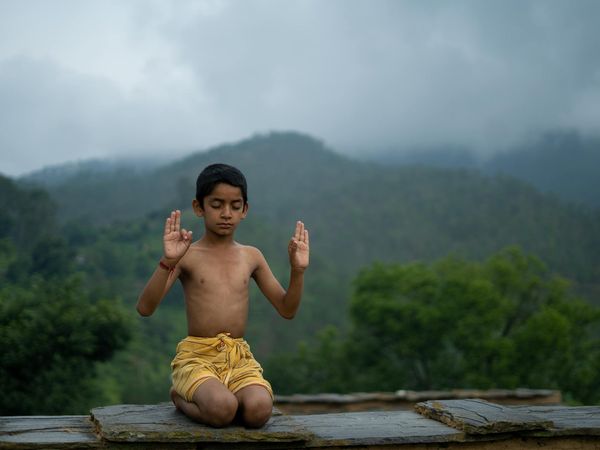 Woman practicing a peaceful yoga pose outdoors.
